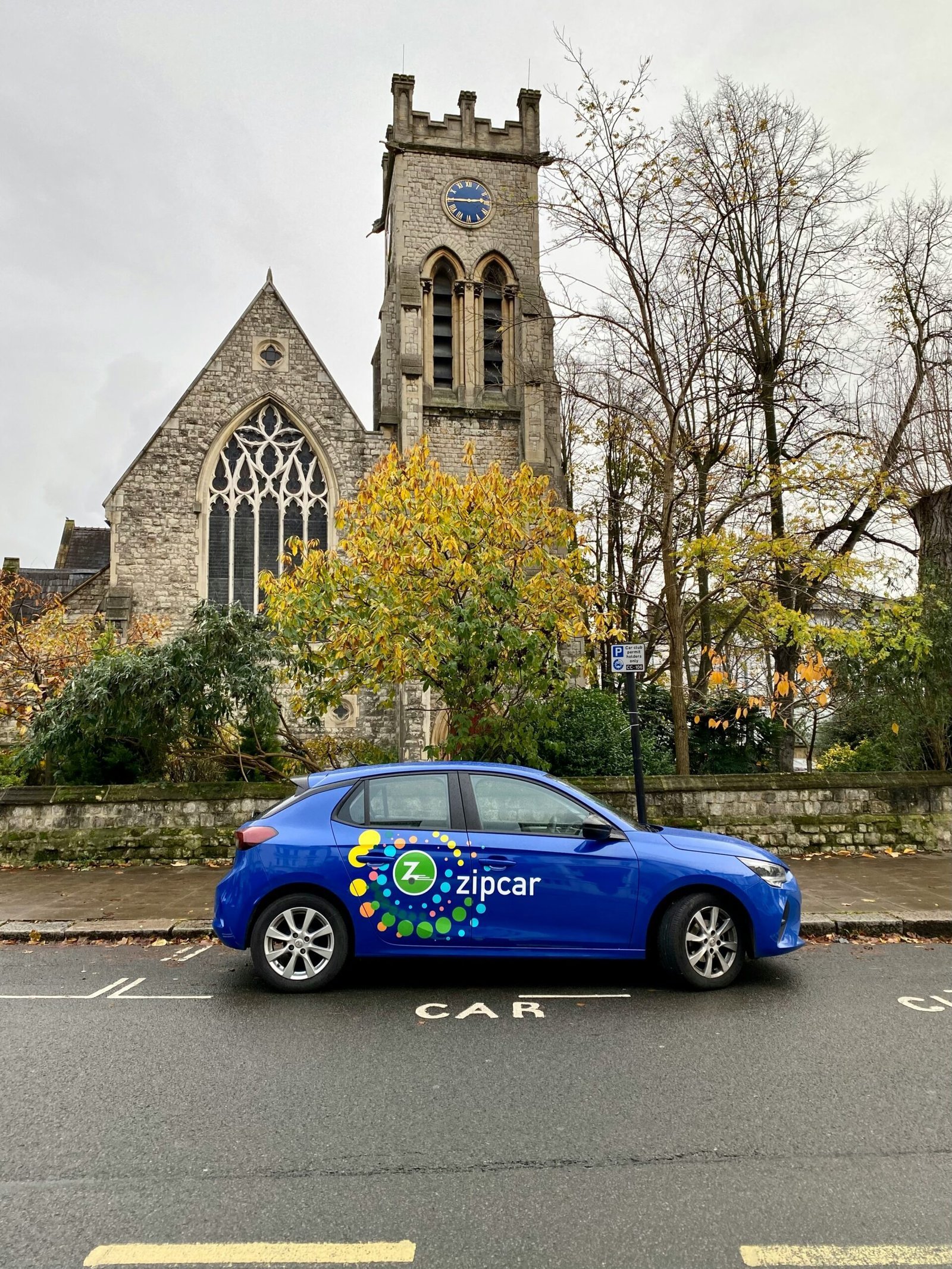 a blue car parked in front of a church